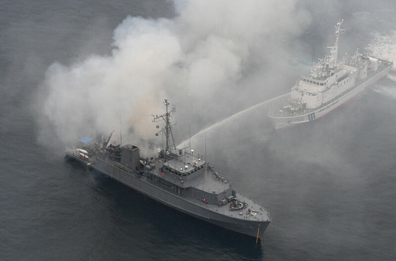 煙を上げる海上自衛隊の掃海艇「うくしま」（手前）に放水する海上保安庁の巡視艇＝福岡県宗像市沖で2024年11月10日午後4時24分、本社ヘリから上入来尚撮影