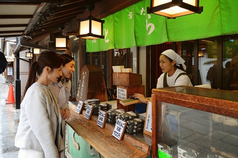 門前とらやの店先は名物の草だんごを求める客でにぎわう。女将との会話も弾む