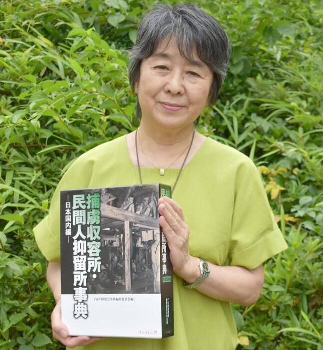 捕虜収容所・民間人抑留所事典を手にする笹本妙子さん