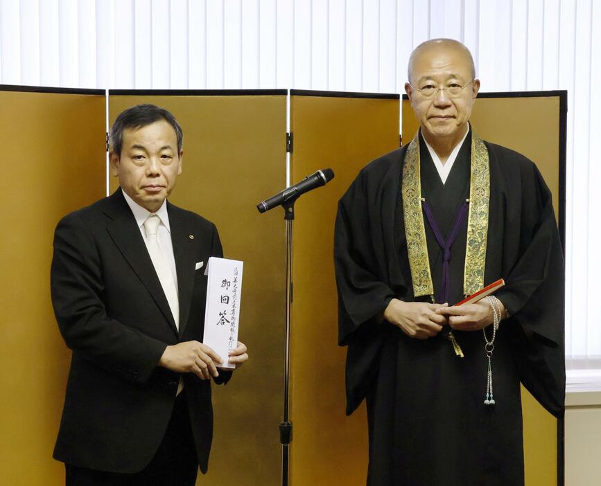 「御開帳」の次回の日程を発表した善光寺の若麻績享則寺務総長（右）＝19日午前、長野市