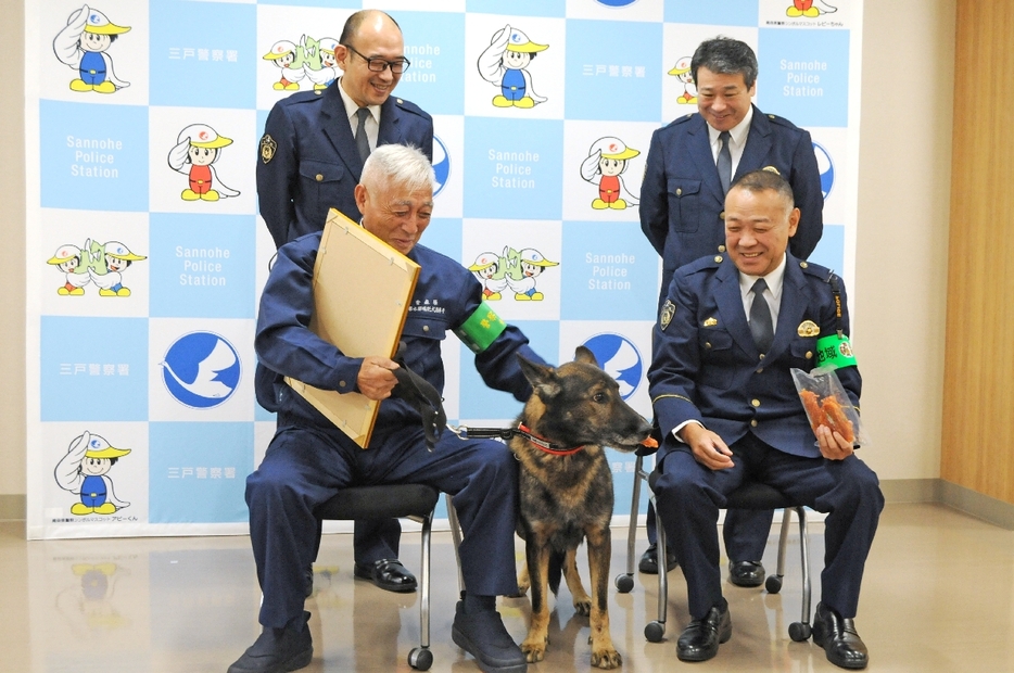 ご褒美を食べるジョン2号をかわいがる小山田松男さん（前列左）