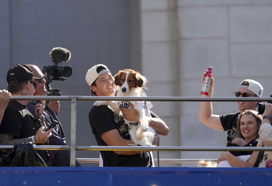 優勝パレードのバスに乗り込み、愛犬のデコピンを抱いて笑顔を見せるドジャース・大谷（AP）