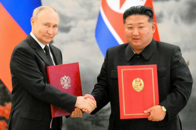 平壌で2024年6月19日、ロシアのプーチン大統領（左）と握手する北朝鮮の金正恩総書記。スプートニク提供=ロイター