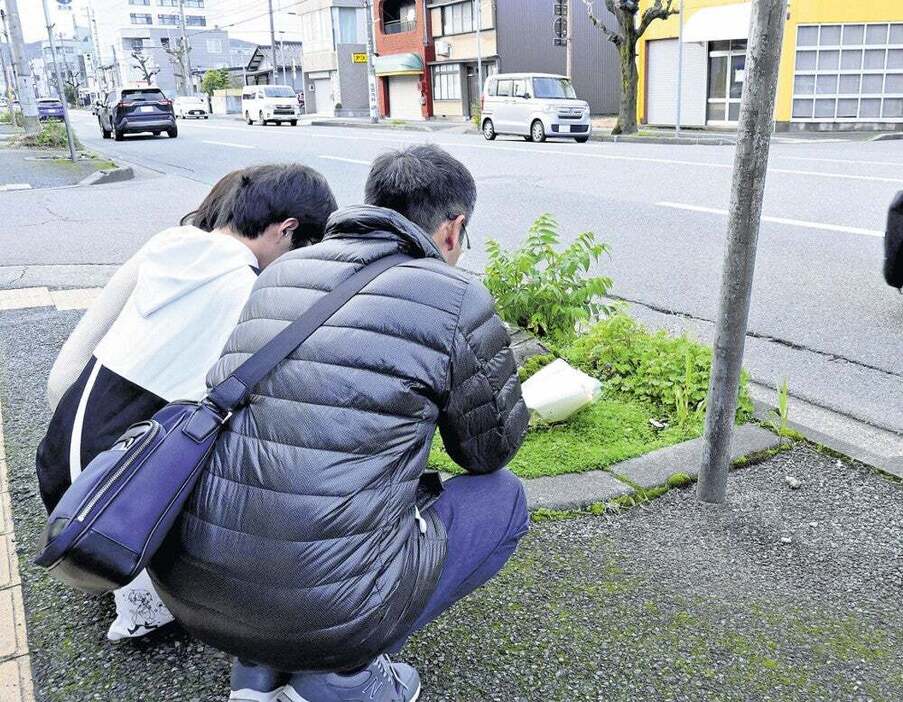 事故現場で家族と手を合わせる治さん（手前、福井市で）