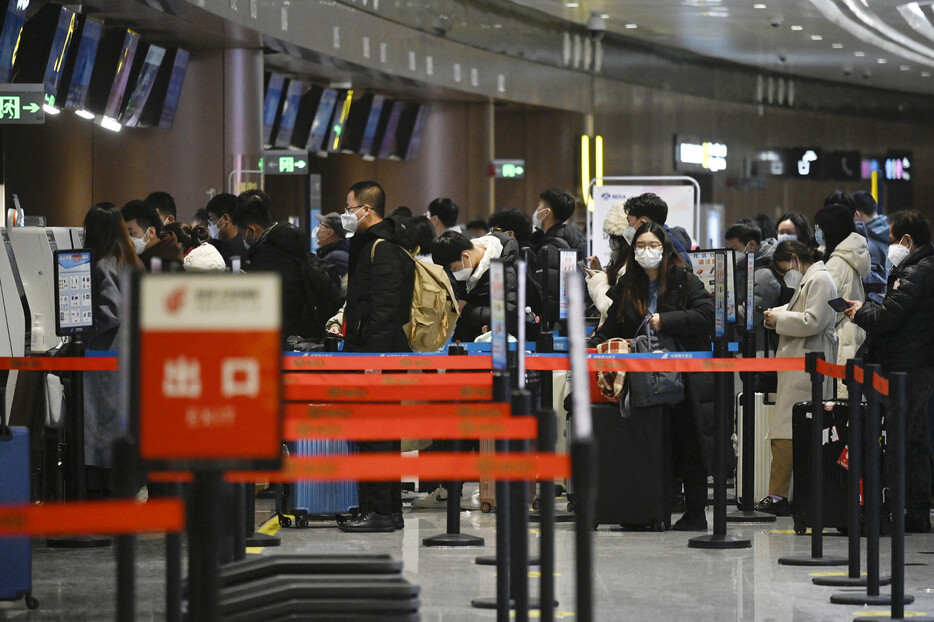 中国政府が日本人向けの短期滞在ビザ免除を３０日から再開することで、国内の航空・旅行各社からは観光やビジネス客の増加に期待の声が上がっている。写真は、北京大興国際空港で並ぶ搭乗客ら＝２０２３年１月撮影