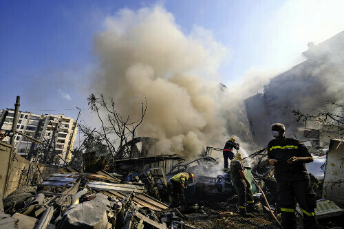 １日、イスラエル軍の空爆を受けたベイルートの市街地で、消火活動を行う市民ら＝ＡＰ