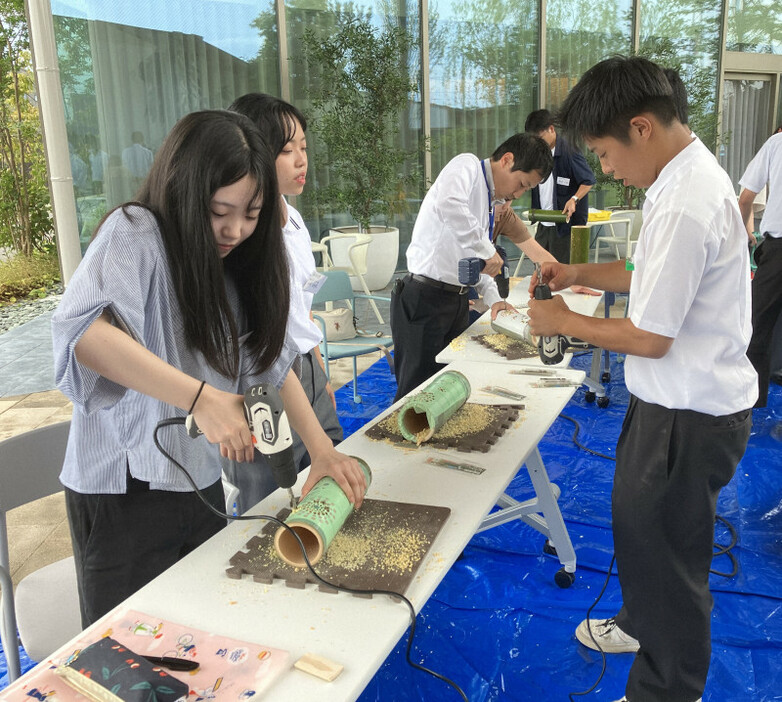 愛媛県西条市内の企業で竹灯籠づくりの講習を行うプロジェクト生（右）ら＝県立西条農業高校提供