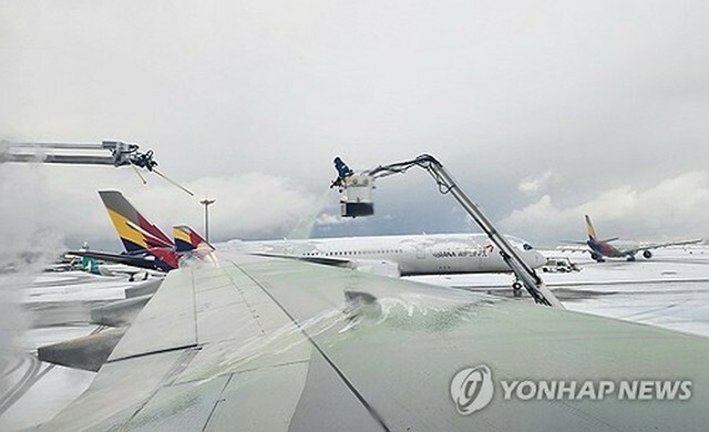 仁川国際空港で機体に積もった雪を溶かす作業が行われている＝27日、仁川（聯合ニュース）