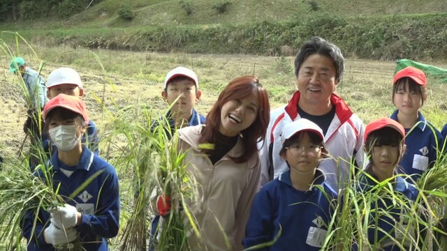 稲刈りに参加した相川七瀬さんと地元の小学生ら