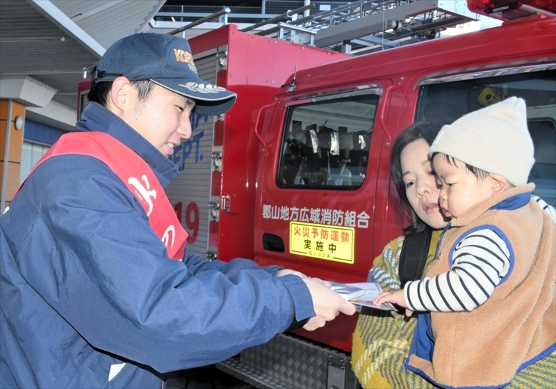 親子に火の用心を呼びかける職員（左）