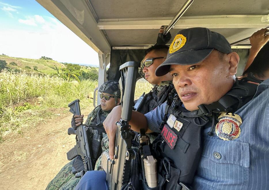 フィリピン南部ミンダナオ島で、フィリス集落に向かう道中、重武装で警護する警官ら＝2024年9月（共同）