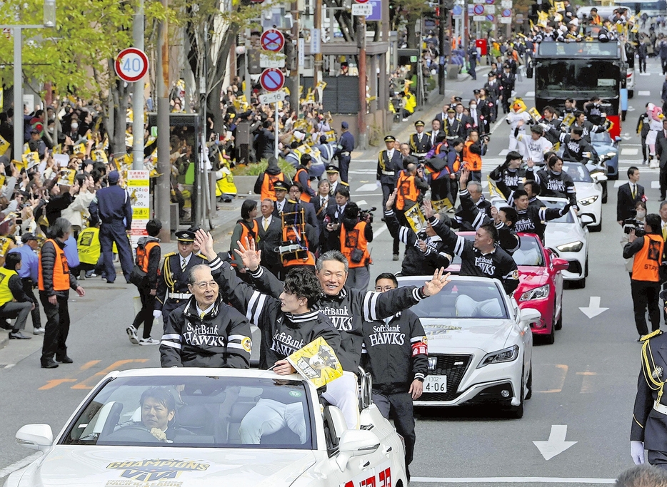 パレードで沿道の歓声に応える（手前の車、右から）小久保監督、周東選手会長、王貞治球団会長ら（24日午前、福岡市博多区で）