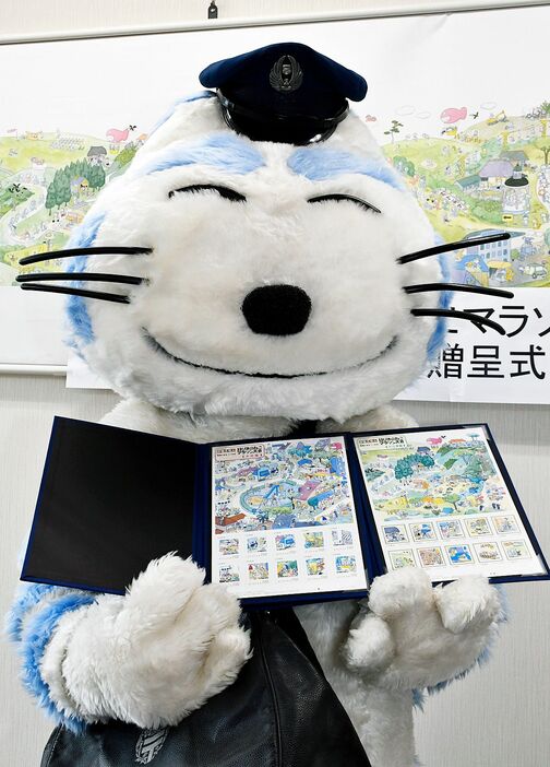 「11ぴきのねこマラソン大会」を題材にしたフレーム切手をPRする郵便局員ねこ