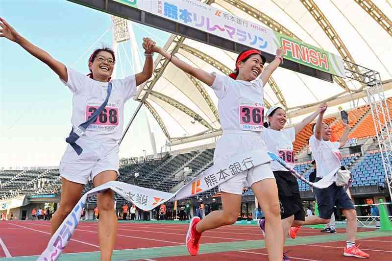 チームメートと笑顔でフィニッシュする参加者たち＝3日、熊本市東区のえがお健康スタジアム（谷川剛）