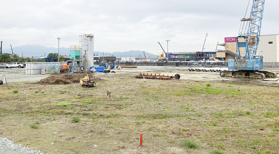 松阪温泉グルースパの建設現場。右後方は松阪公民館の入るイオンタウンB棟＝大塚町で