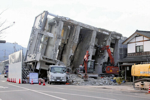 能登半島地震で倒壊して公費解体が進むビル。重機で建物の側面から崩している（１５日、石川県輪島市で）＝福原悠介撮影