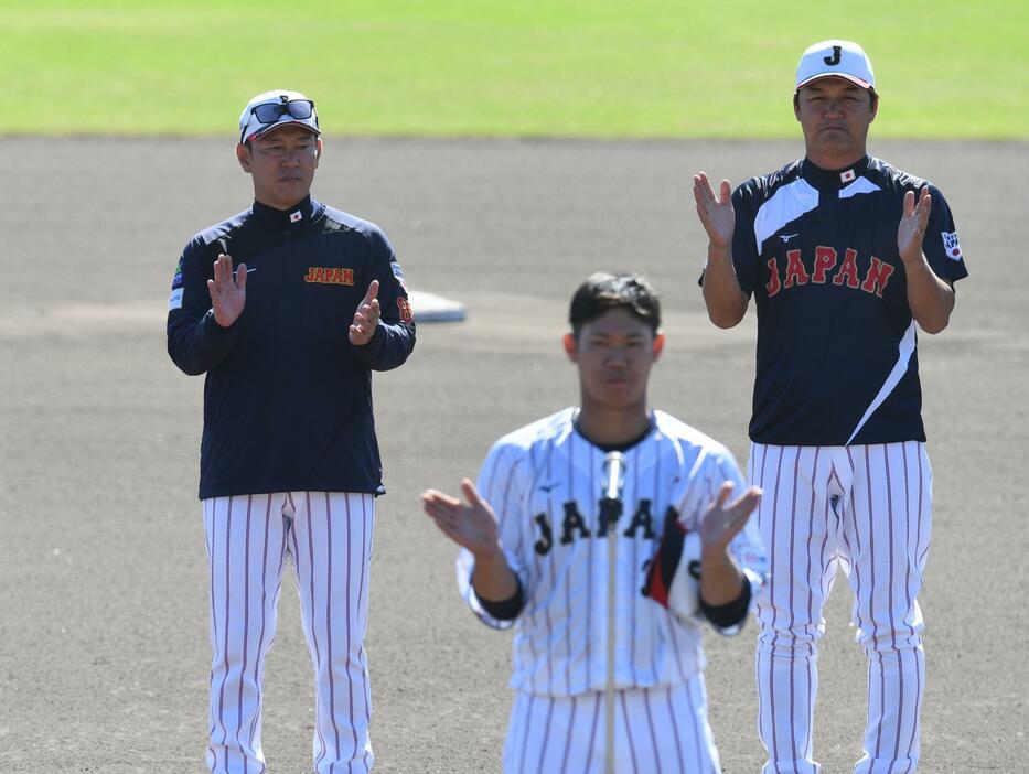 　坂倉（下）の音頭で手締めをする井端監督（左）＝撮影・佐々木彰尚