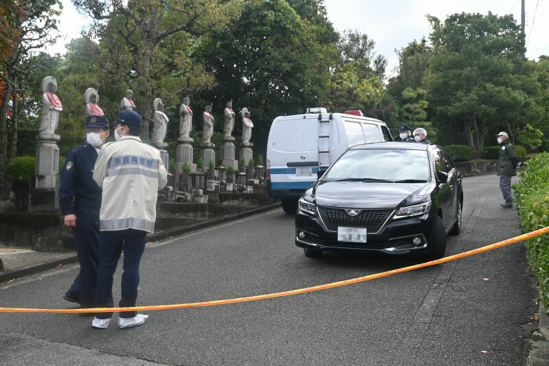 遺体が見つかった霊園で警備に当たる県警の警察官ら＝奈良市富雄元町4の四天王寺大和別院で2024年11月19日午前9時39分、田辺泰裕撮影（画像の一部を加工しています）