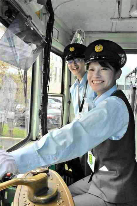 熊本市電の運転士として独り立ちした柴田温香さん（右）と松下源さん＝13日、熊本市中央区