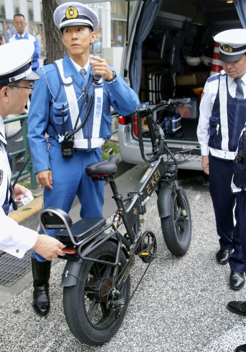 改正道交法が施行され、モペットの車体を調べる警視庁の警察官＝1日、東京都新宿区