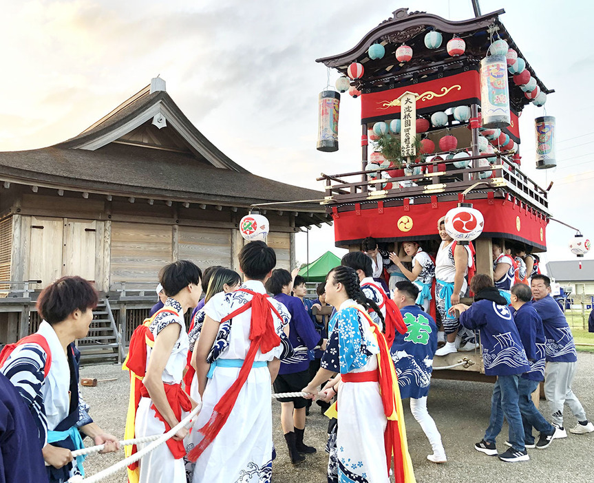 山車を引き回す大淀の3地区のメンバーたち＝明和町斎宮のさいくう平安の杜前の復元道路で