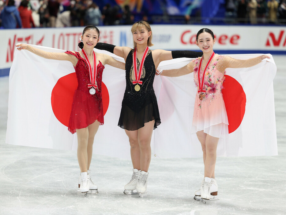 ＮＨＫ杯フィギュア。優勝し笑顔を見せる坂本花織（中央）。左は２位の千葉百音。右は３位の青木祐奈＝９日、東京・国立代々木競技場