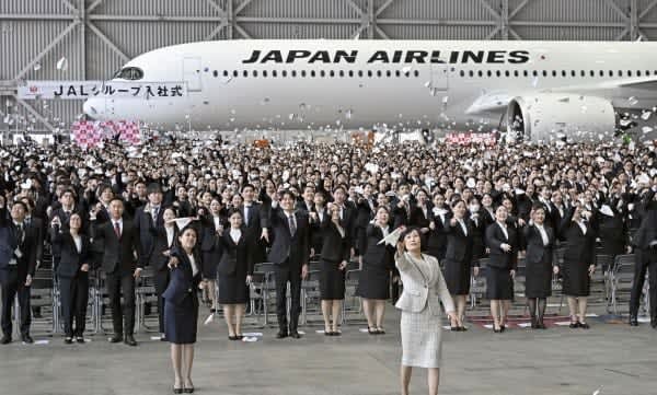 日本航空グループの入社式で紙飛行機を飛ばす新入社員ら。手前右は鳥取三津子社長＝２０２４年４月１日、羽田空港