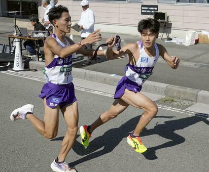 2024年11月3日、全日本大学駅伝、駒大の7区・篠原倖太朗（左）からたすきを受けるアンカー・山川拓馬　写真／共同通信社