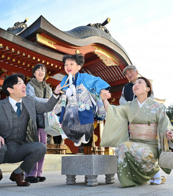 晴れ着姿で碁盤から飛び降りる男の子＝１４日、盛岡市八幡町・盛岡八幡宮