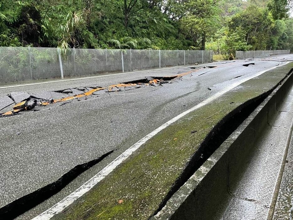 大雨の影響で路面が隆起し、割れが発生した県道14号（県提供）