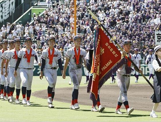 第１０６回夏季甲子園表彰式で優勝旗を持ち行進する京都国際高校の選手ら。［写真　朴慶洙］