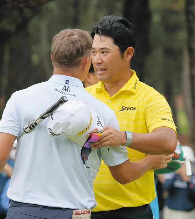 最終日、ホールアウトし、優勝したマックス・マクグリービー（手前）をたたえる松山英樹