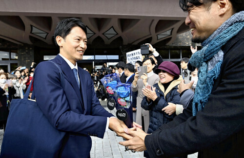 初登庁し、集まった人たちと握手する斎藤氏（左）（１９日午前、兵庫県庁で）＝飯島啓太撮影