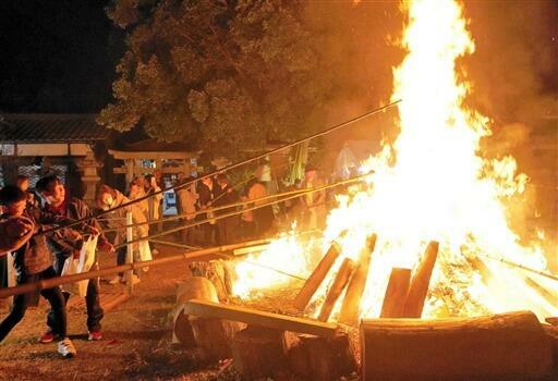 生せんべいを焼く参拝者=11月20日夜、福井県敦賀市栄新町の天満神社