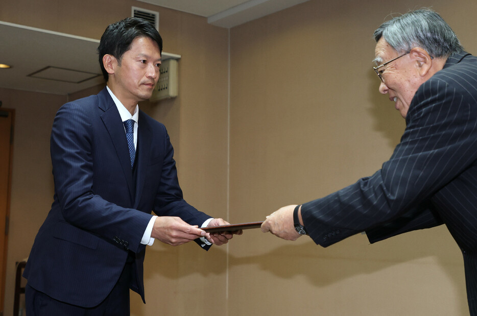 １７日投開票の兵庫県知事選で再選を果たした斎藤元彦氏（左）は１９日午前、当選証書を受け取った後、就任式に臨み、２期目をスタートさせた。午後には就任後初の記者会見を行う予定＝神戸市中央区