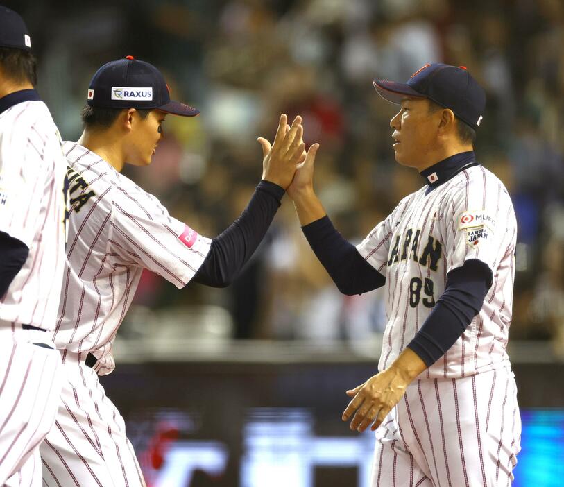 　韓国に勝利し森下（左）とタッチする井端監督（撮影・山口登）