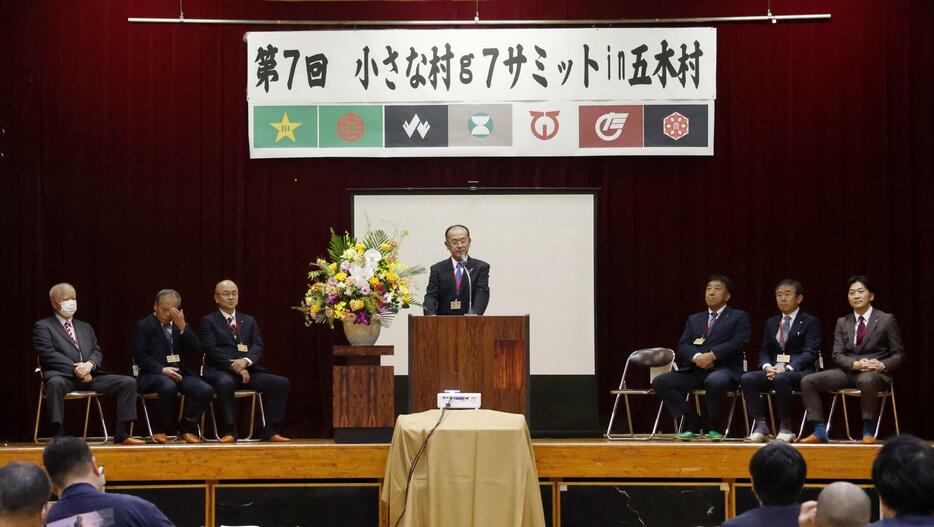 「小さな村g7サミット」の開会宣言をする熊本県五木村の木下丈二村長（中央）＝8日午後、五木村