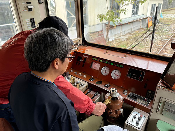 元神岡鉄道の運転士だった運転体験の指導運転士から、機器操作の説明を受ける。頭ではどのような操作が必要か理解しているつもりだったが、いざ着座すると緊張してしまった（遠藤イヅル撮影）。