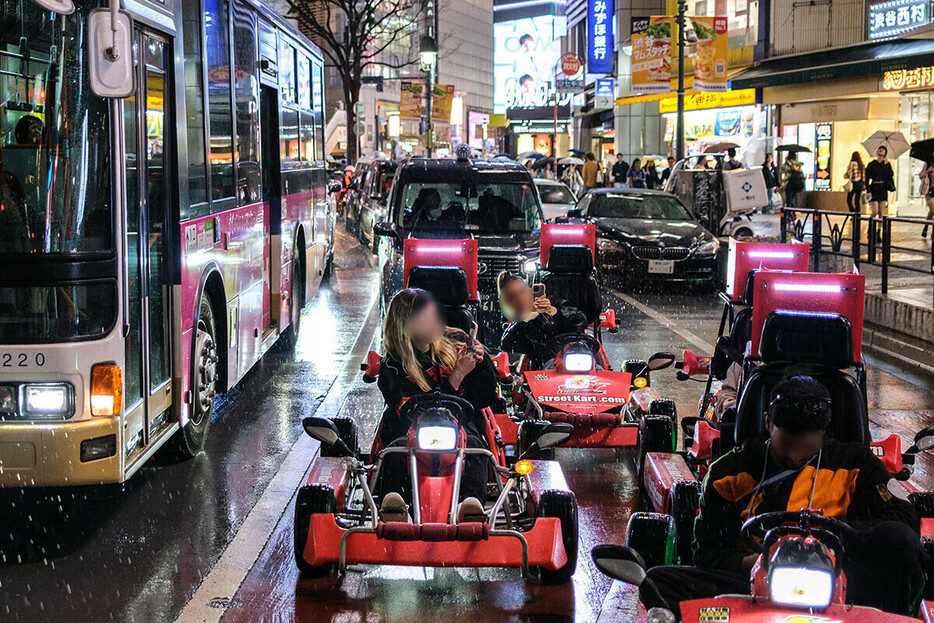 訪日外国人が運転する公道カート。ご覧のように雨の中の信号待ちでもスマホでの撮影に余念がない。まさにトラブルの種