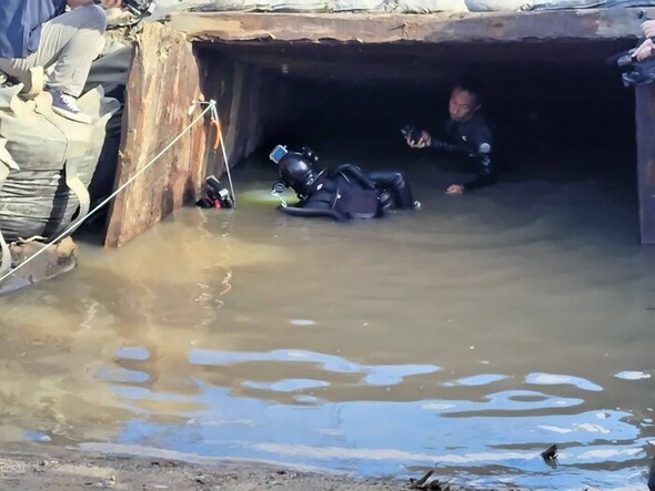 先月30日、山口県宇部市の長生炭鉱水没事故の犠牲者の遺骨を探すため、専門のダイバーが坑口から海底へと続く坑道へと入っていくところ=「長生炭鉱の水非常を歴史に刻む会」提供