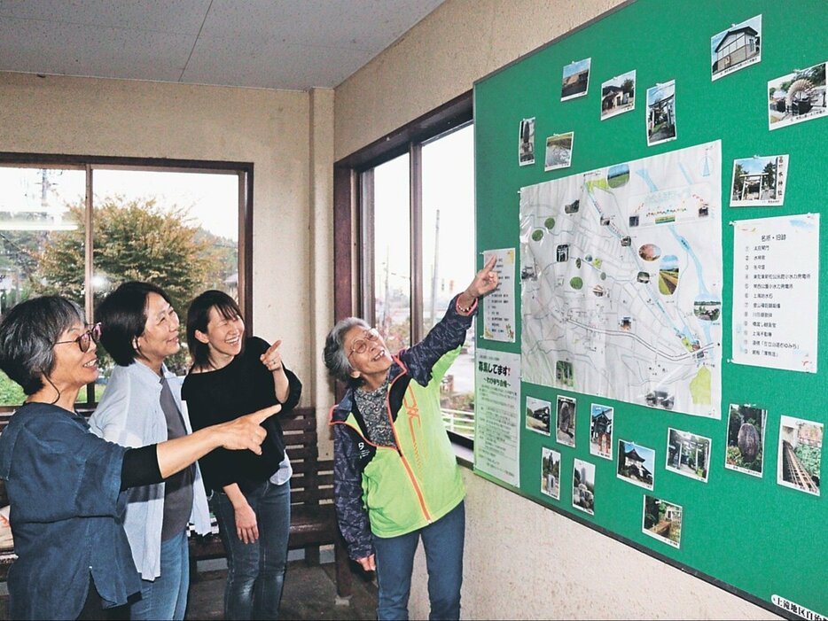 大川寺駅に掲示した手作りの地図を紹介する駅ガールズのメンバー