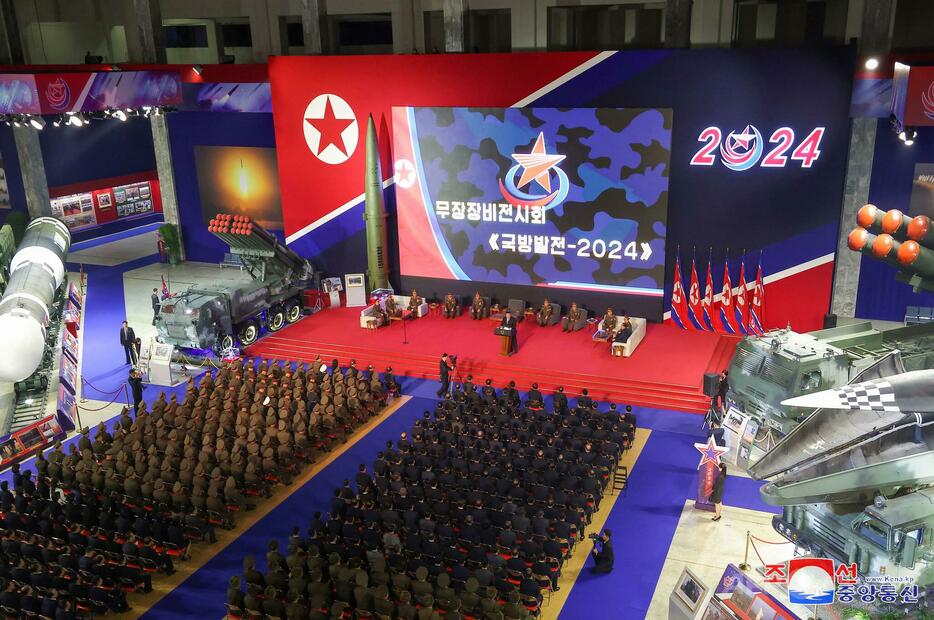 北朝鮮の首都平壌で、最新兵器展示会「国防発展2024」の開会式に出席する金正恩（キム・ジョンウン）朝鮮労働党総書記（中央壇上、2024年11月21日撮影、同22日公開））。【翻訳編集】 AFPBB News