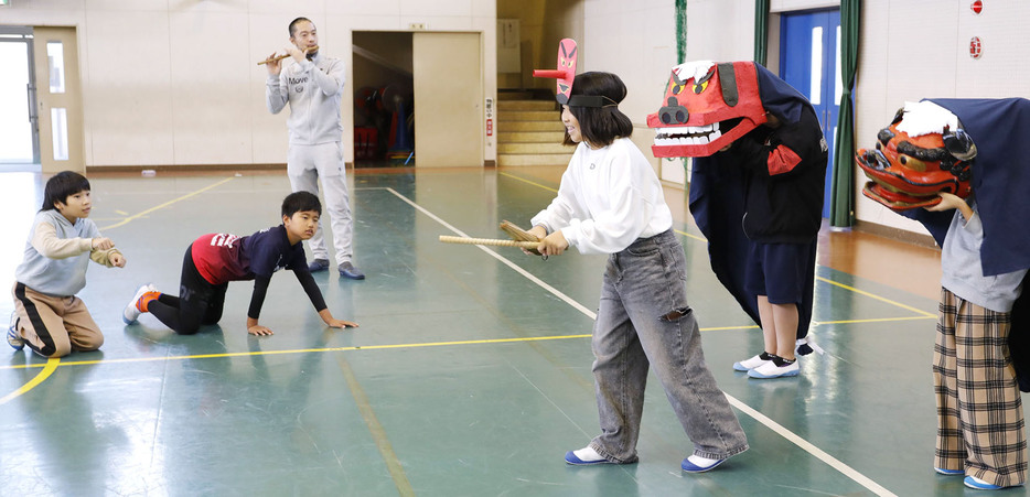 城代さん（左から3人目）の指導で練習する児童たち＝松崎浦町の松ケ崎小で