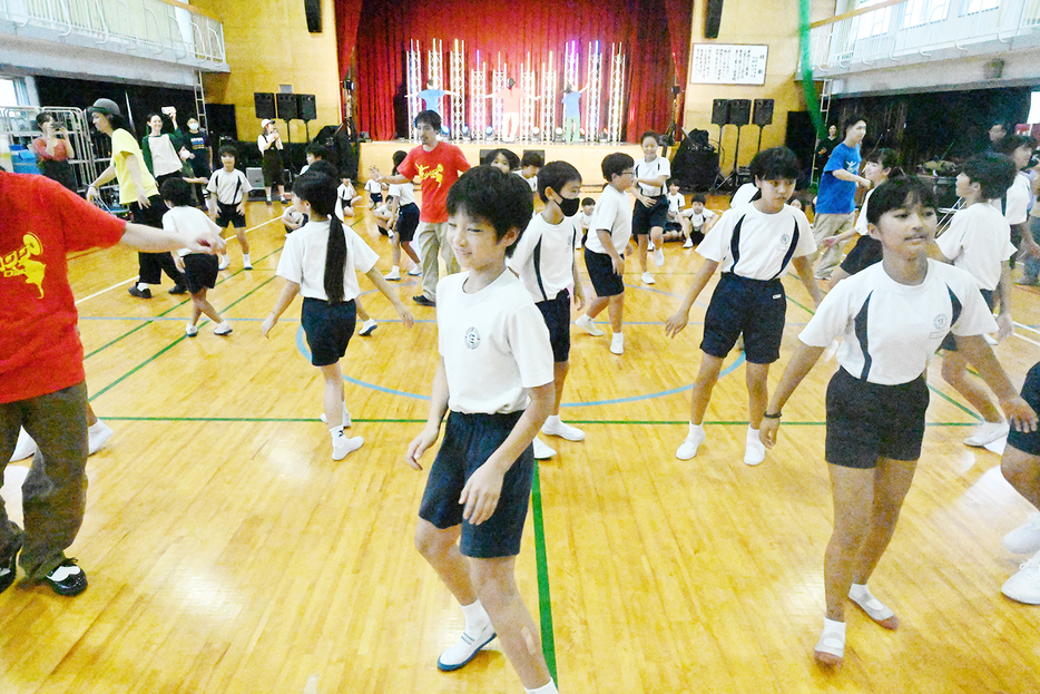 プロのダンサーと一緒に踊る児童たち（13日、知名町）