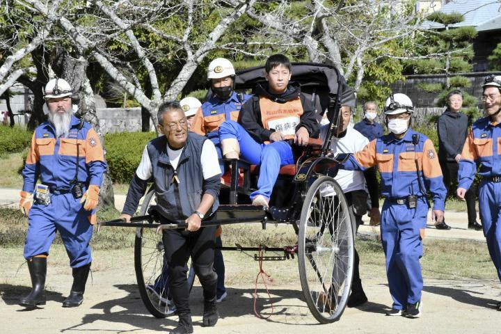 道後地区の合同防災訓練で負傷者を搬送する人力車＝7日午前、松山市道後公園