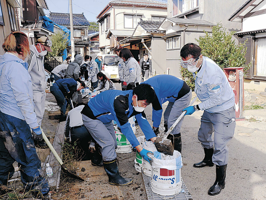 泥かきボランティアを行う松田社長（右）＝輪島市内