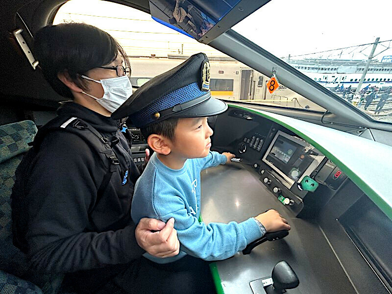 新幹線の運転台見学で運転士気分を味わう親子