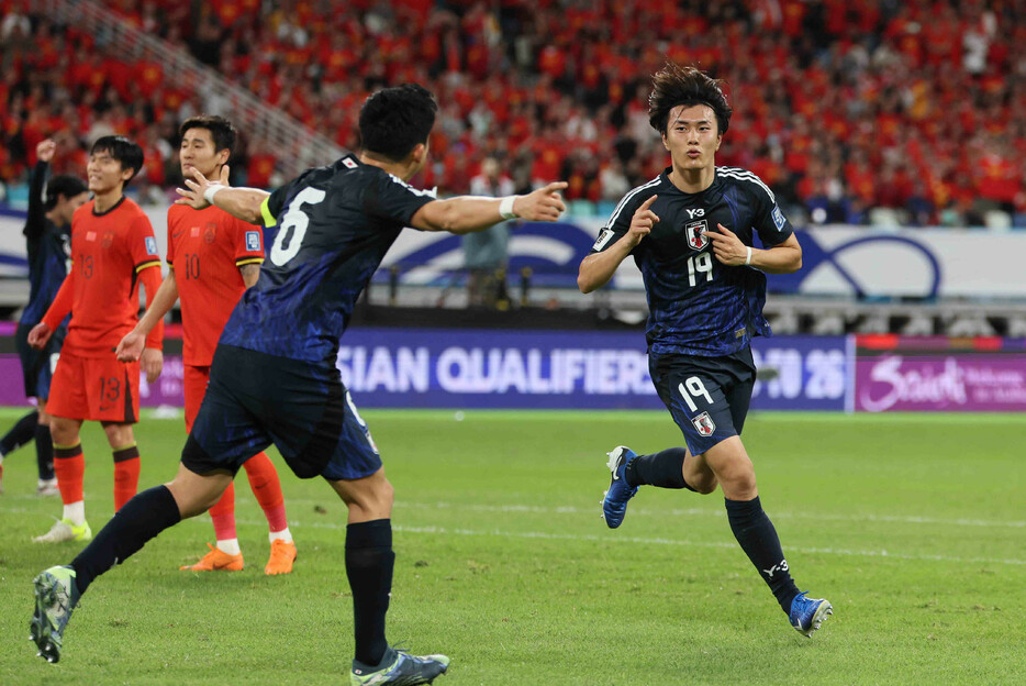 サッカーＷ杯予選。中国戦の前半、先制ゴールを決めて喜ぶ小川（右）＝１９日、中国・アモイ