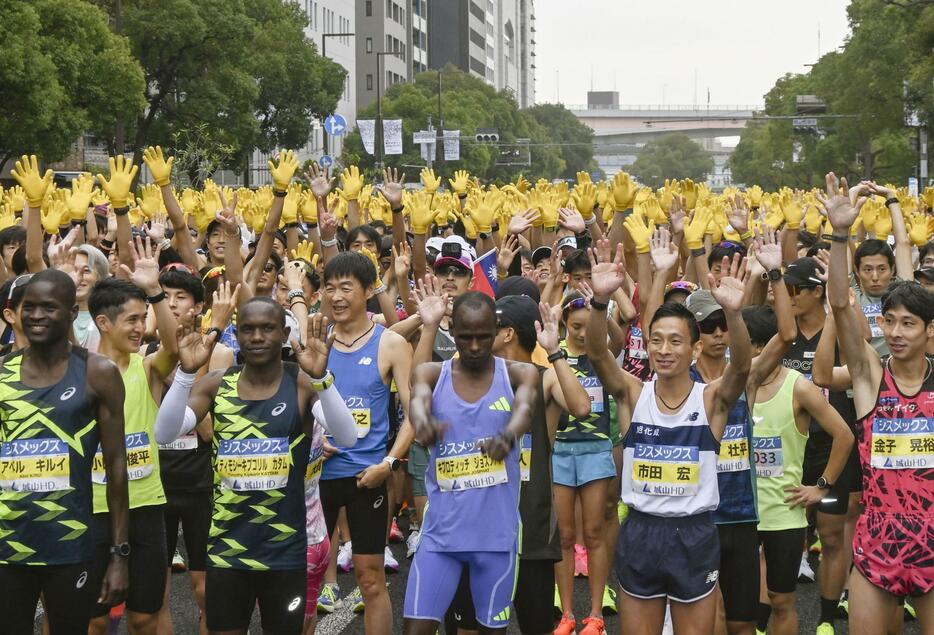 神戸マラソンで、復興の象徴のヒマワリを表す黄色の手袋を着けたランナーたち＝17日午前、神戸市