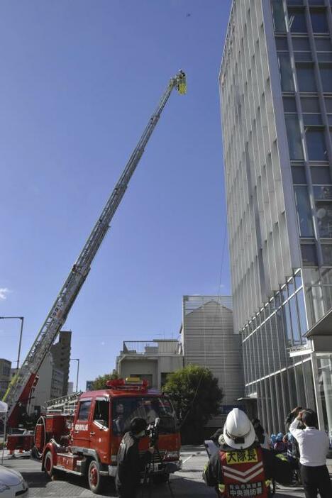 はしご車でビルの屋上に取り残された人を救助する訓練＝7日午後、松山市大手町1丁目